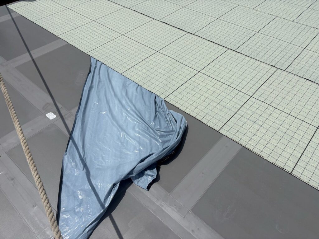 【屋上防水】<br />
自着シート貼り付け<br />
（既存の下地との隙間を作ってくれる通気性能シートになります。）